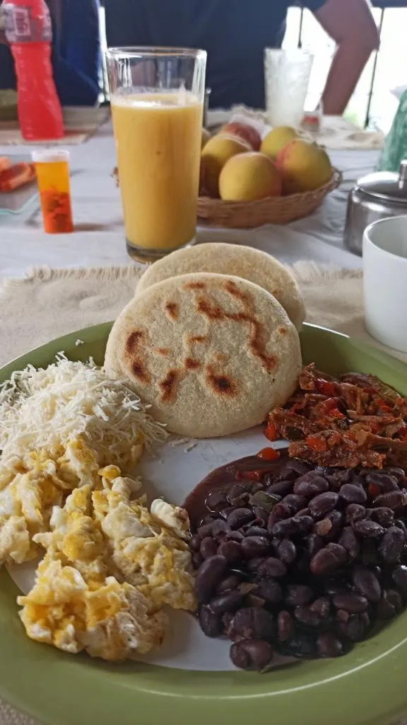 Desayuno criollo: arepas, huevo, caraotas y jugo de mango